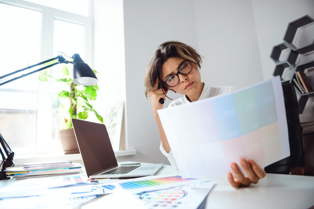 Young beautiful businesswoman in glasses sitting at workplace in office.